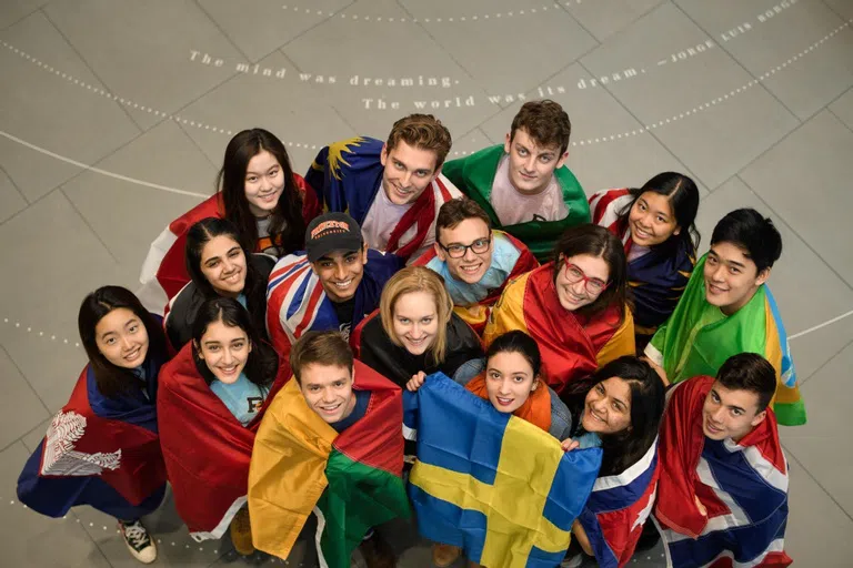 Students wrapped in various country flags. 