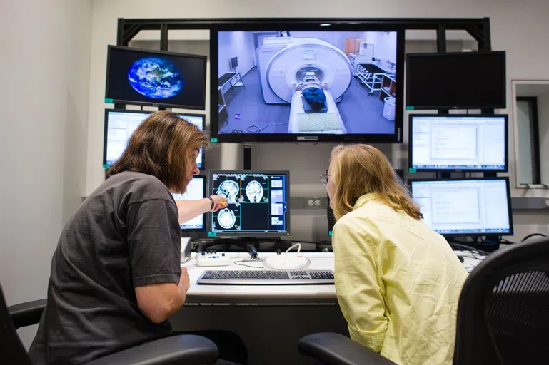 Individuals looking on screens in a lab