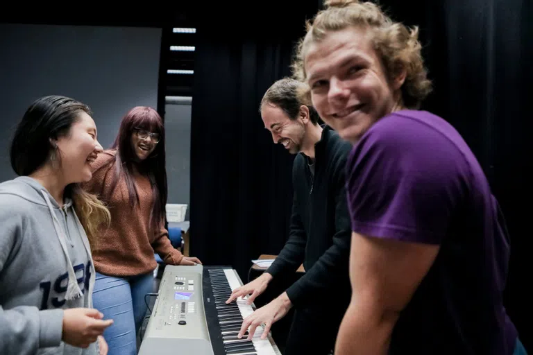 Students around a keyboard