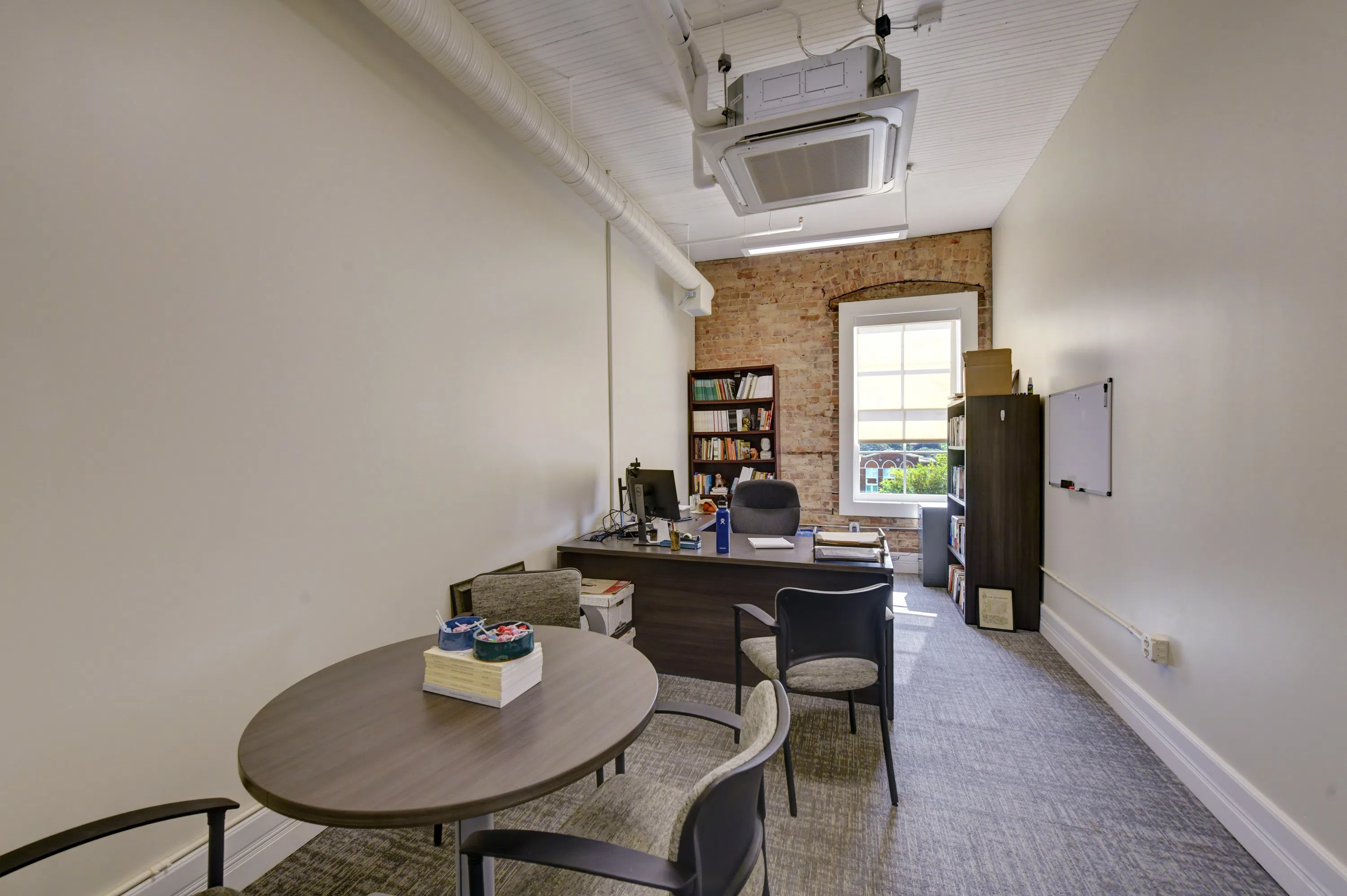 Photo of faculty office with desk, chair, table, bookshelf, and other items located on the third floor of Staples Hall.