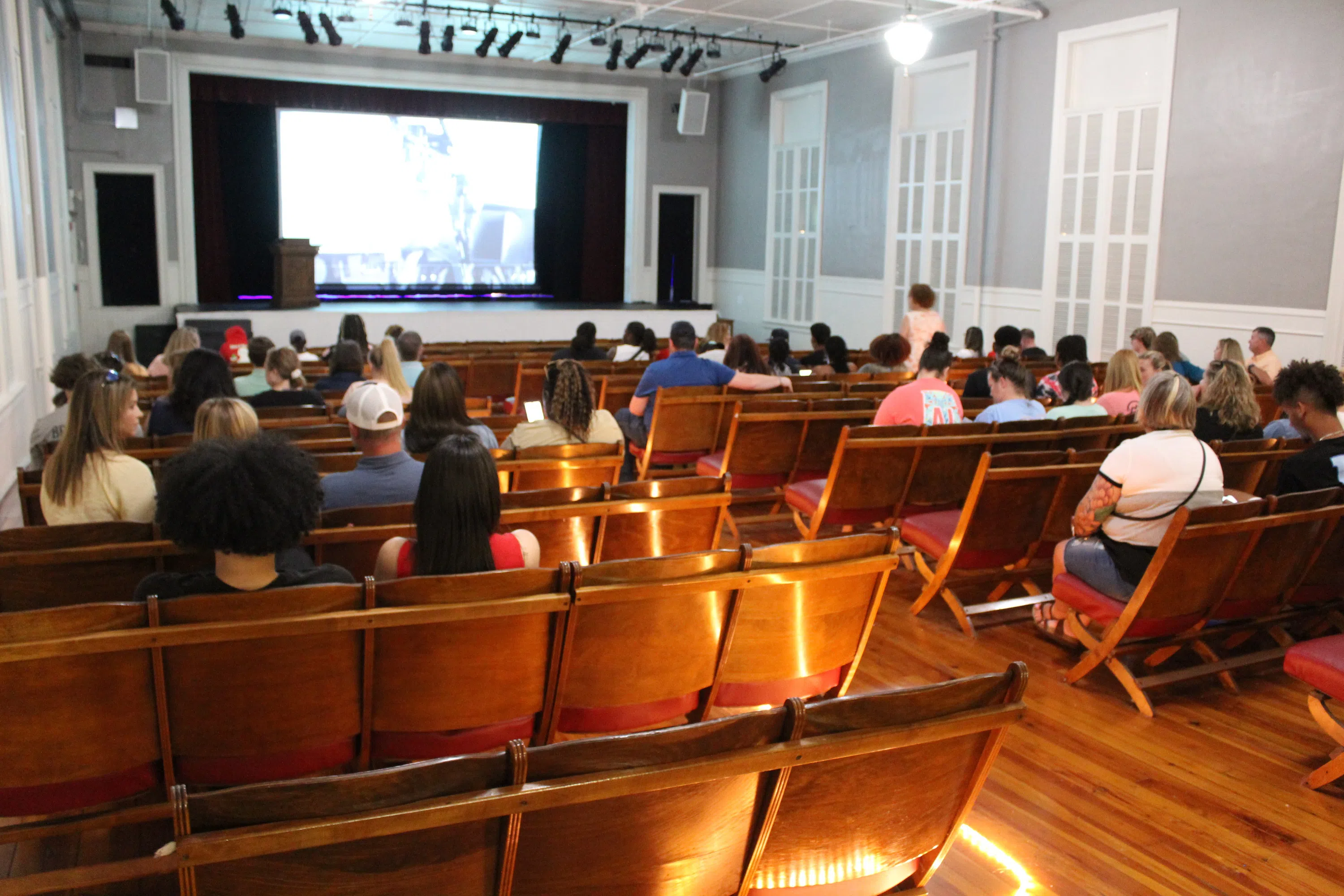 Students and parents attend an orientation event in the theatre at Old Main.