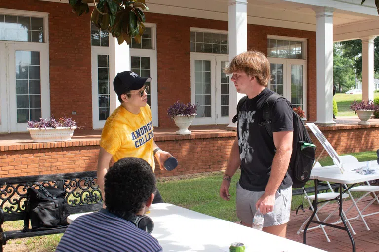 Dr. Kim talks with a student during Club Rush held on the patio outside of Turner Dining Hall.