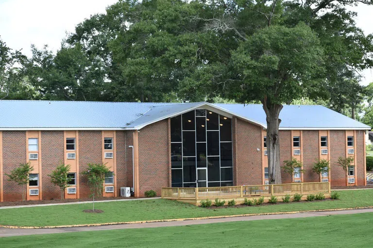 Outside of Mitchell Residence Hall with front deck and lawn.