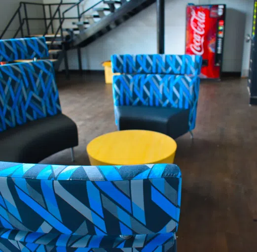 Lobby furniture, staircase and soda machine in lobby of Mitchell Residence Hall.