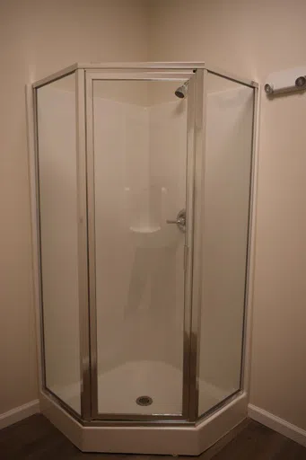 Images of the two sink vanity and lighted counter space and a shower stall located in a Patterson House.