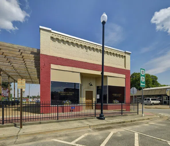 Image of the outside of the Richard B. Taylor Music Center from the street with a little view of Magnolia Alley and the wooden canopy that hangs above the alley.