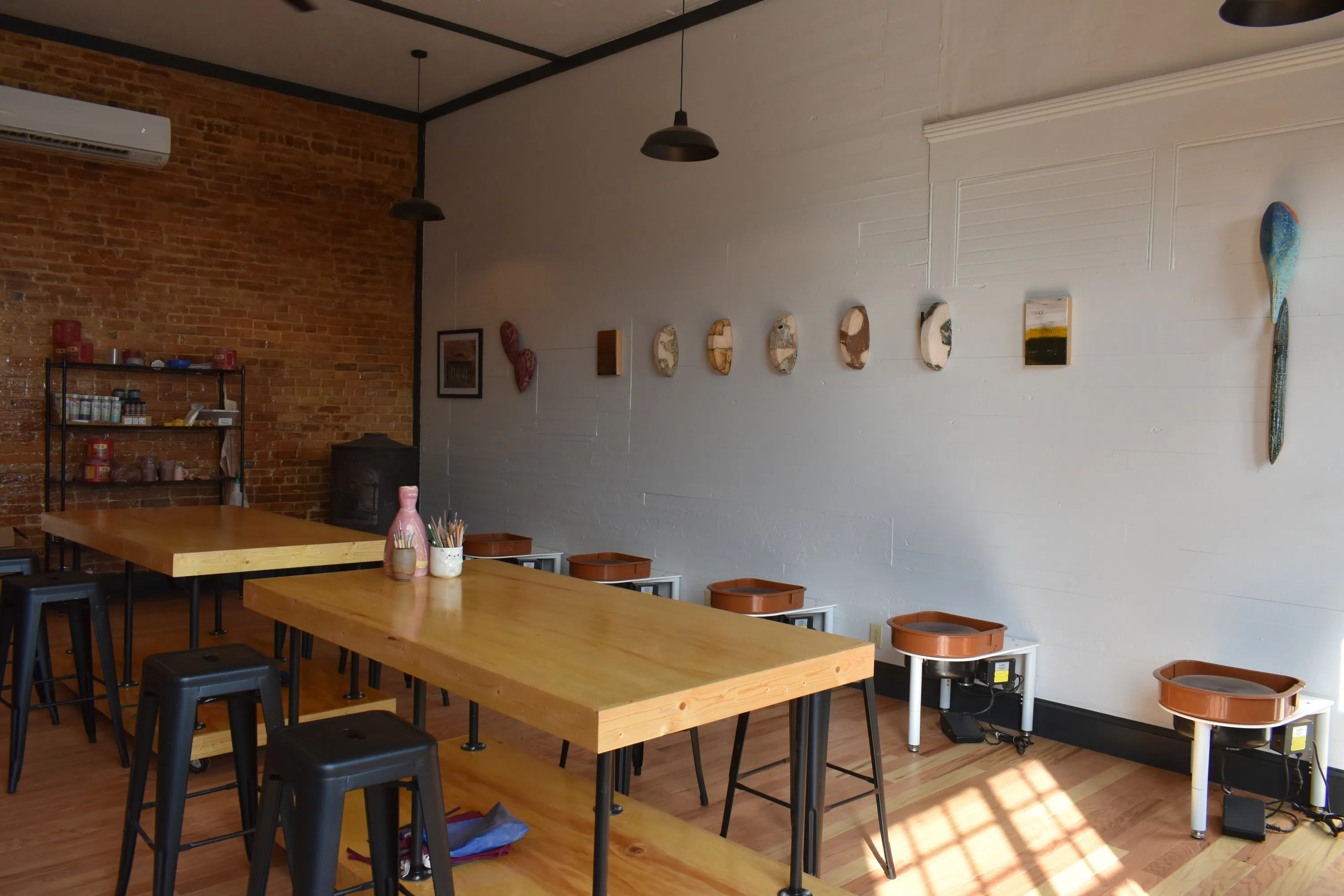 Images of the Berryman Ceramics Studio interior with students, professor, and guests.  Work spaces and various ceramics pieces also pictured.