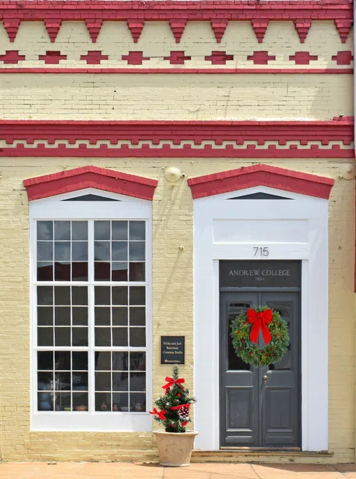 Outside of the Berryman Ceramics Studio Building pictured with a Christmas wreath and small tree in a pot by the door.