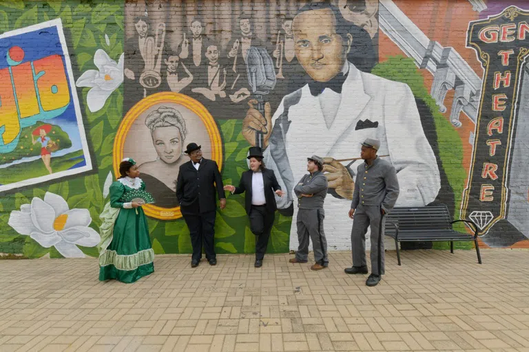 Image of Andrew College theatre students against the backdrop of the mural painted in Magnolia Alley featuring Fletcher Henderson, Jr. and Liddie Murphy.