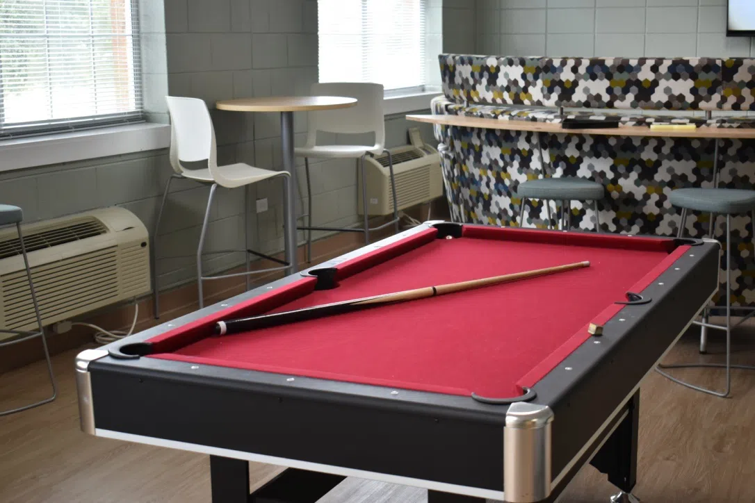 Image of the pool table and other furniture located in the lobby of the Rhodes Residence Hall.