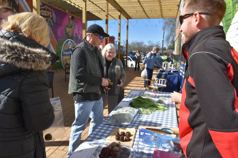 Local vendors sell goods to customers in Magnolia Alley.