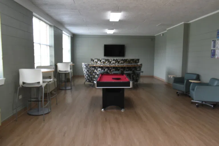 Wide shot of Lower Floor in Rhodes Men's Residence Hall with seating and pool table.