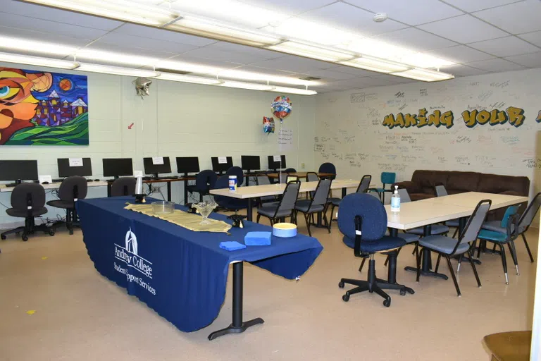 Classroom meeting space with computers, chairs, and tables.  