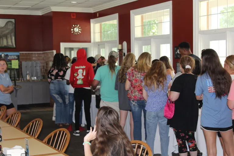 Students and parents gathering for meal in dining hall during orientation.