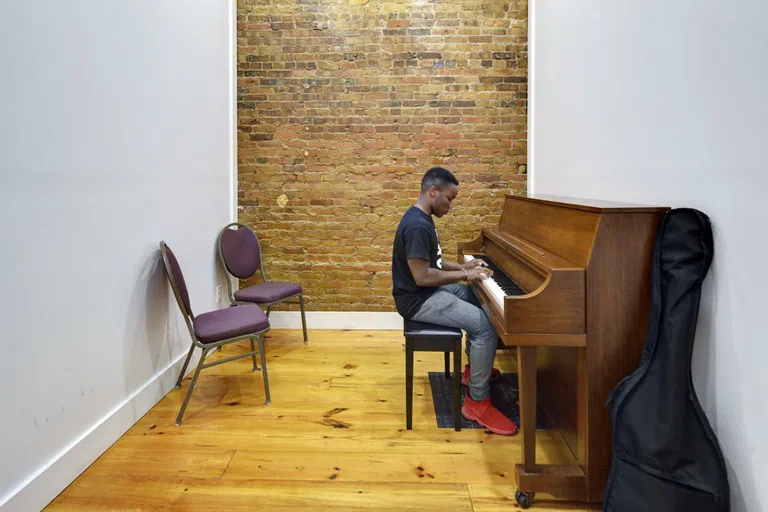 Image of a male music student playing the piano in a private rehearsal room located inside of the Richard B. Taylor Music Center on the campus of Andrew College.