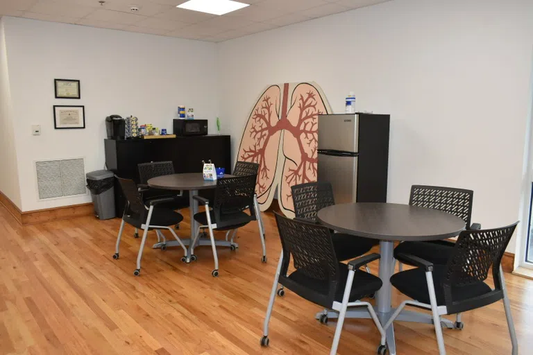 Image of a study area in the Respiratory Therapy program located inside Jones Chapel on the campus of Andrew College.  Image with lung artwork, tables, chairs, microwave, and refrigerator.