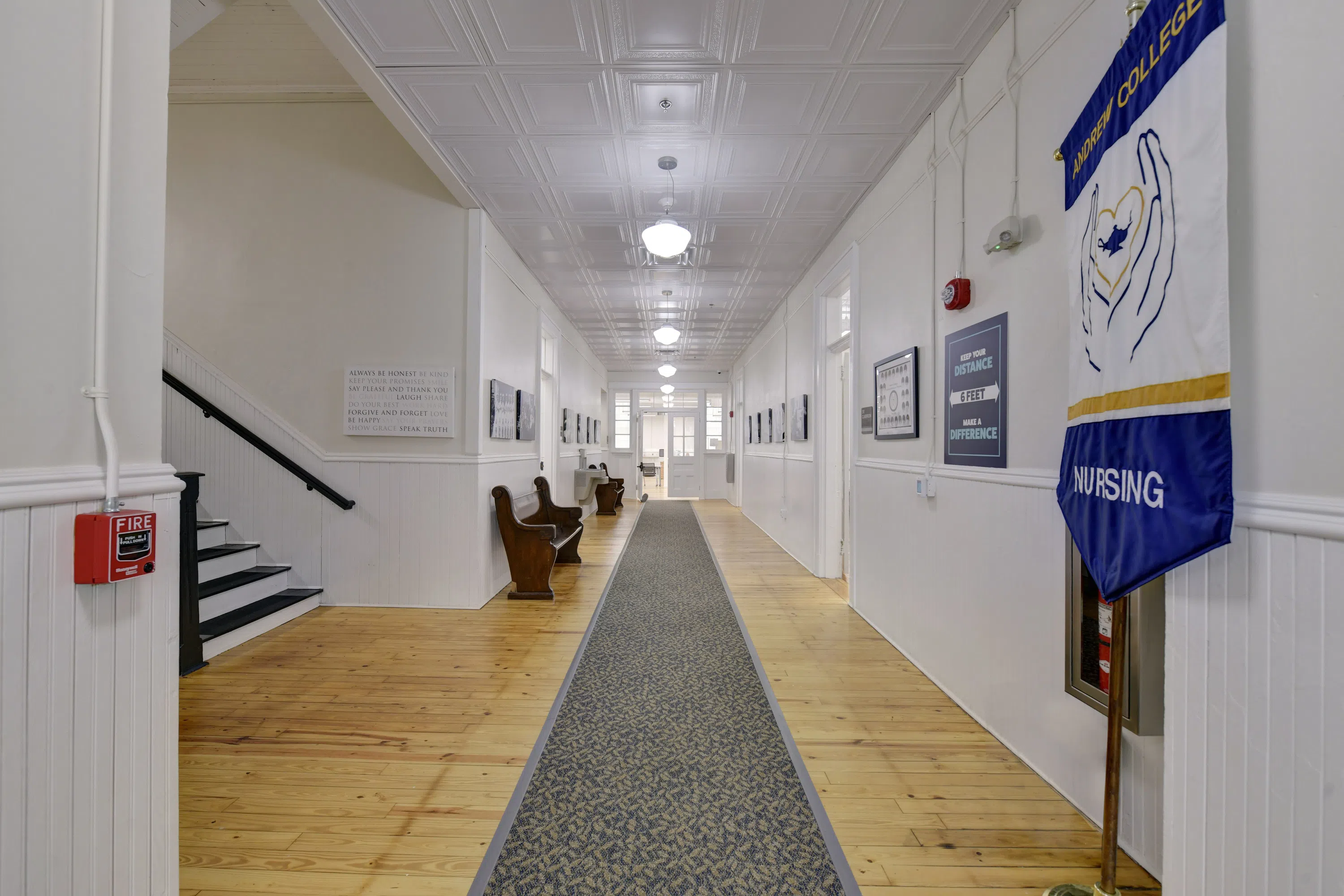 Open hallway with a nursing banner, staircase, and doorways to classrooms, and nursing faculty offices located on the second floor of Staples Hall.