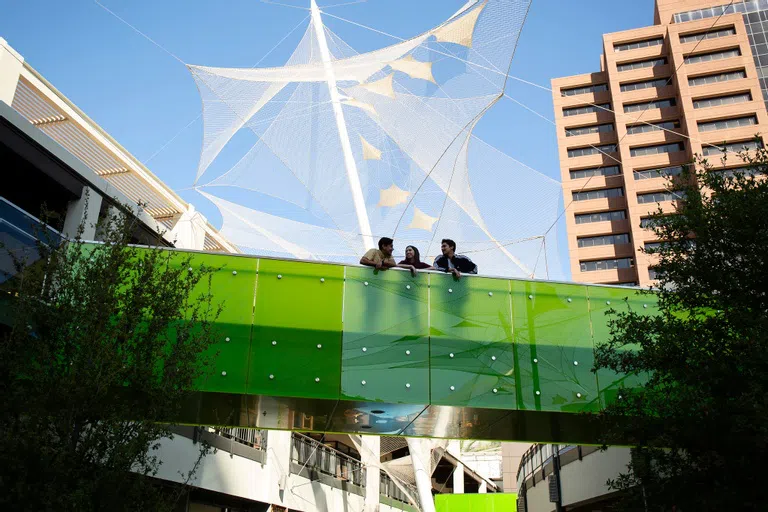 ASU Students stand on a bridge between buildings at Arizona Center