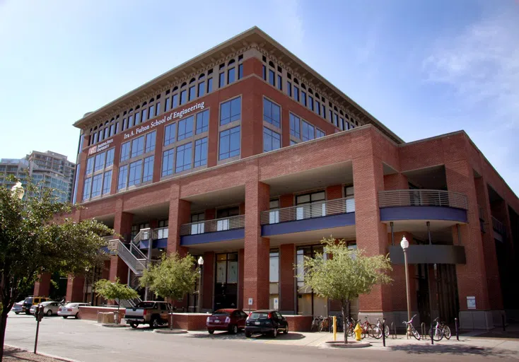 Street with parking in front of a six-story brick building with ASU and Ira A. Fulton Schools of Engineering signage at the top. 