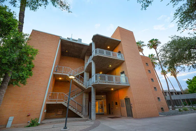 Three story brick building with exterior staircase. 