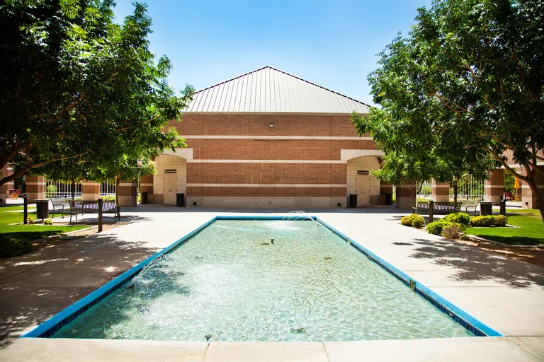 A rectangular fountain leads up to a striped brick building with doors on either side labeled Kiva Lecture Hall. 