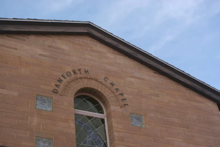 Brick building with words "Danforth Chapel" written over a stained glass window.