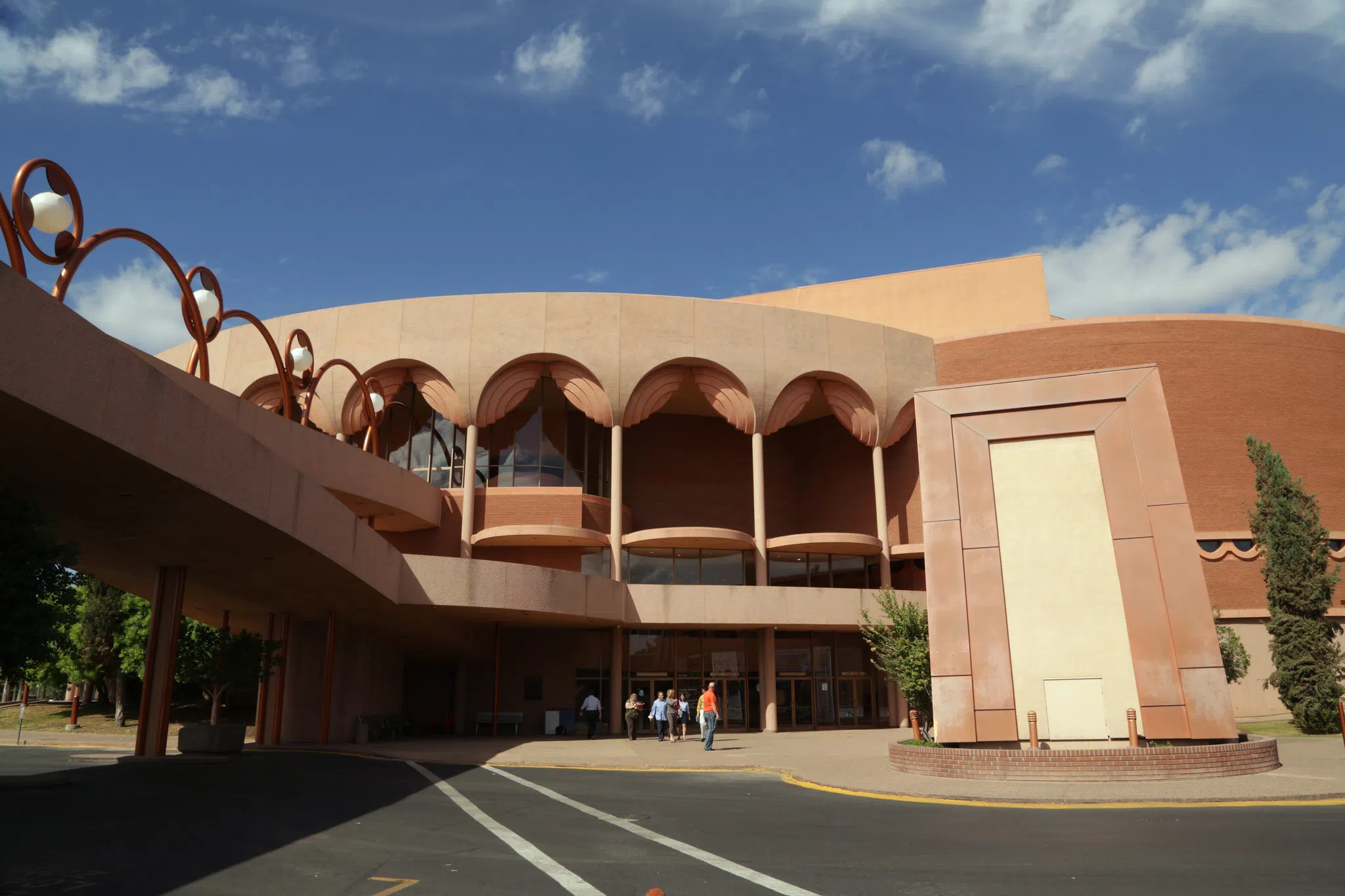 Entrance to red brick round building, with a scalloped detail along roofline.