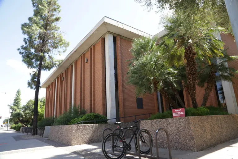 A bicycle sits in front of a red brick two-story building.