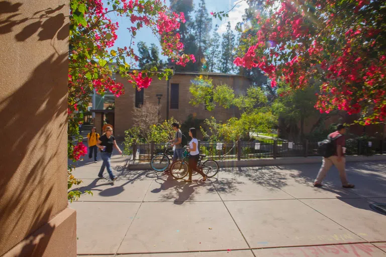 Four students walk by a small brick chapel.