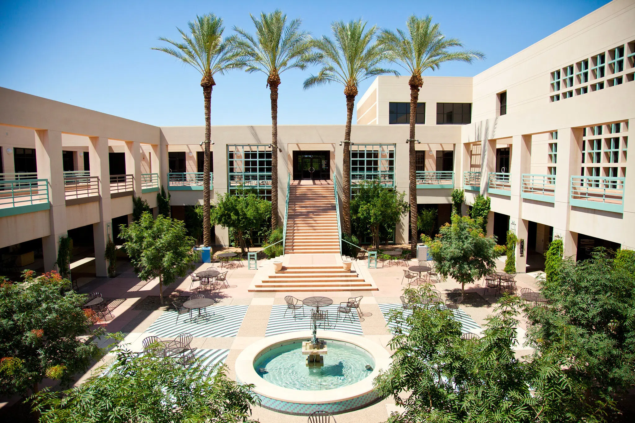 two story courtyard with fountain in the middle.