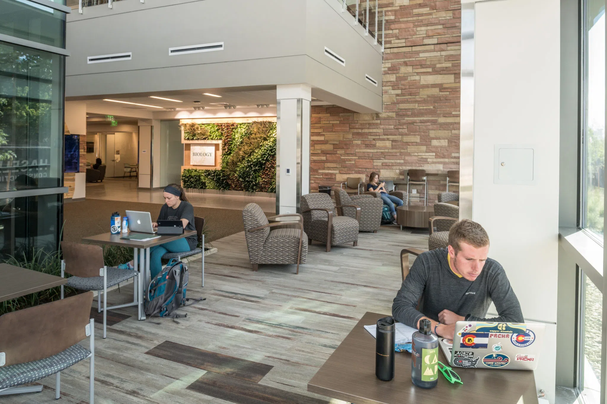 The lobby of the Biology building. A student sits at a table.