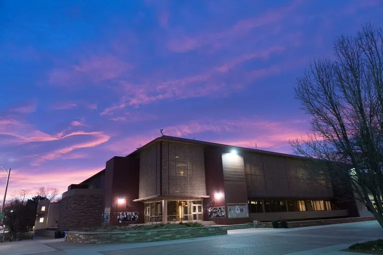 The outside of Clark C Wing underneath a sunset.