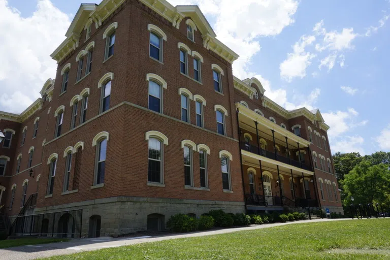 Large 4 story red brick building with large glass windows