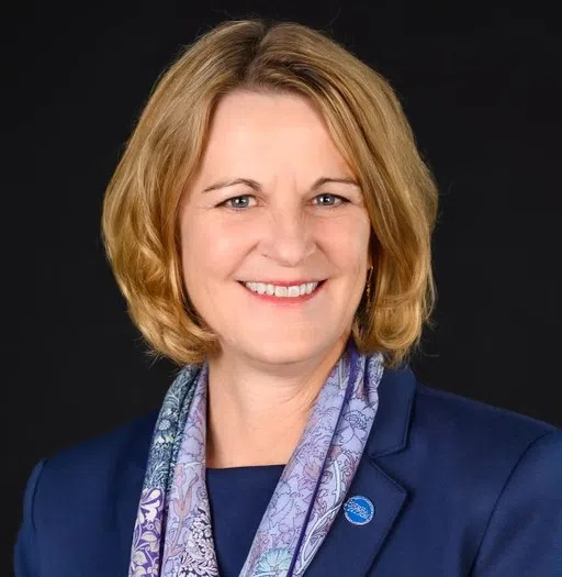 President Dr. Cheryl L. Nixon smiles wearing a blue jacket and scarf. Pinned to her left lapel is a Berea College pin. 