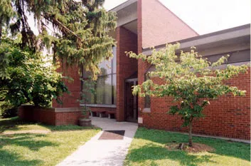 Photo of exterior of  red brick building with tall windows.