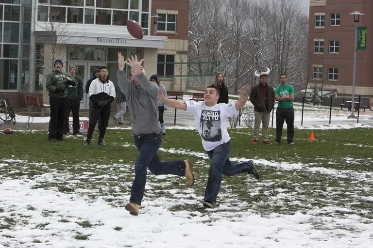 Students playing football while participating in Newing Navy.