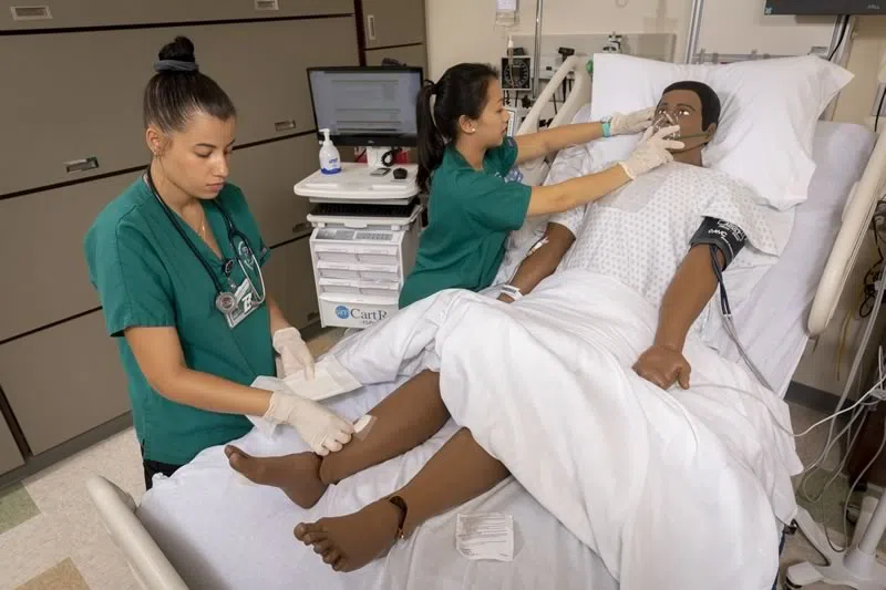 Students using the simulation manikins in the Decker College of Nursing 