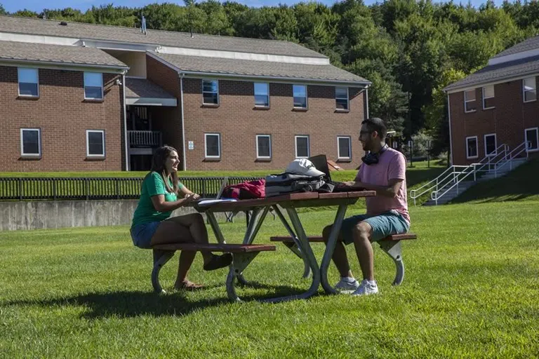 Students sitting together outside the apartment community buildings