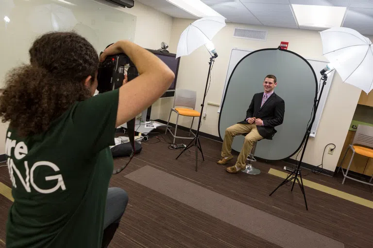 Students getting headshot photos taken and participating in a career fair. 