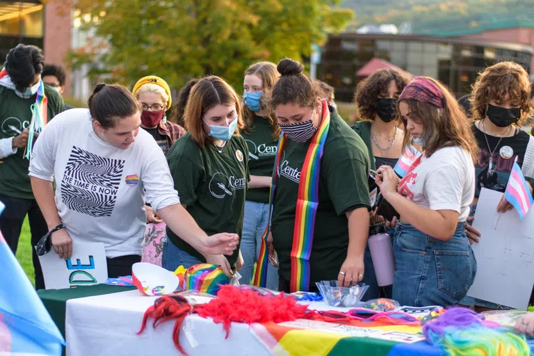 Students at an on campus event with rainbow flags and prizes. 