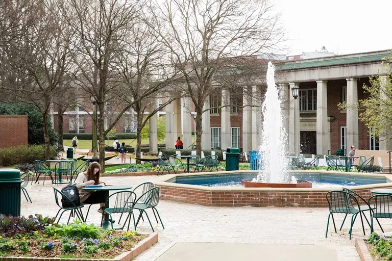 Norton campus fountain and students lounging in the sitting area surrounding 