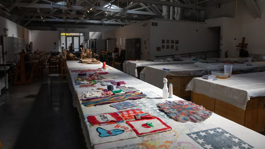  Long tables with colorful pieces and spray bottles  on top of them.