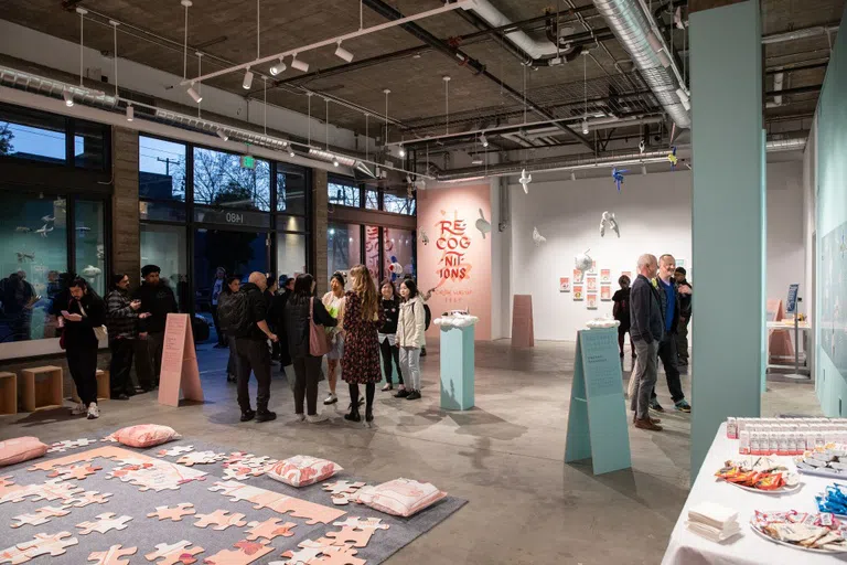 A crowd gathers in a pastel-painted gallery for the opening of Recognitions / 认 • 知, a solo exhibition by Christine Wong Yap.