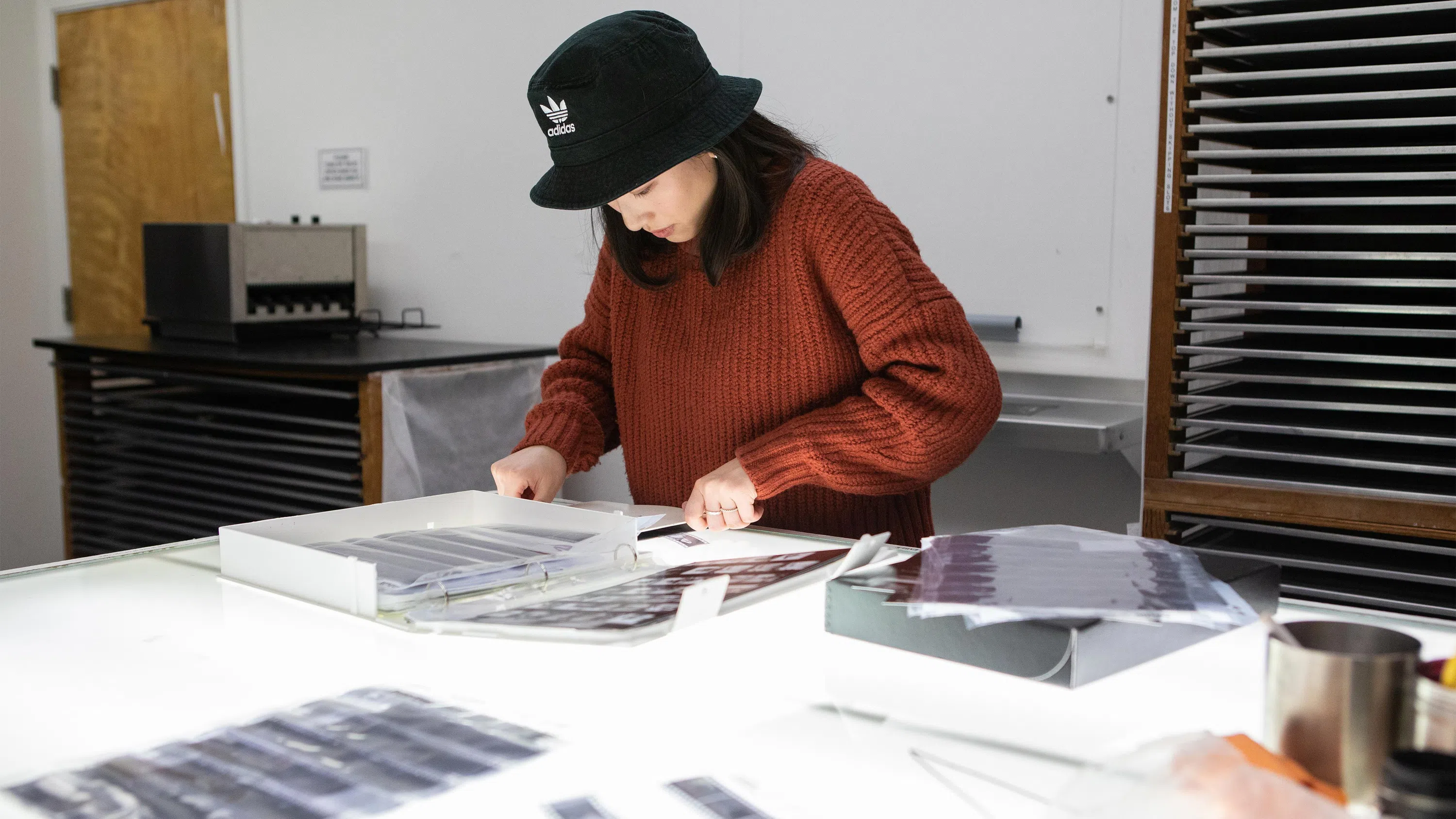 A student decides which negatives to print before heading into the darkroom.