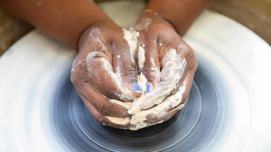 Close up of hands on a pottery wheel.