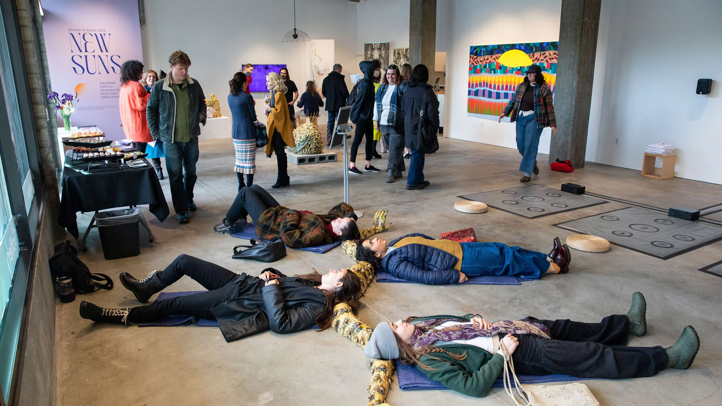 People lying on the ground with their head inserted onto a ceramic object. 