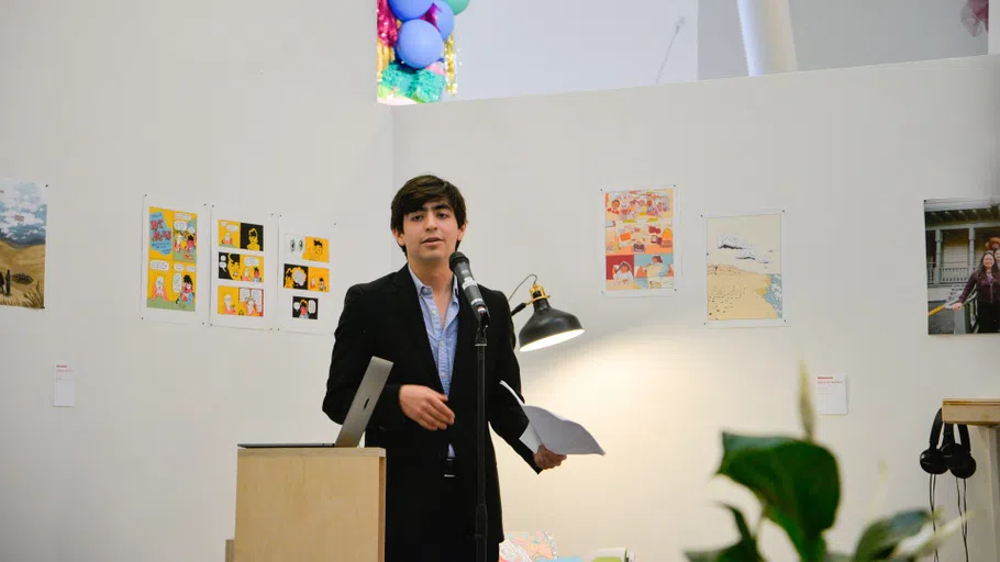 A student stands at a podium reading work.