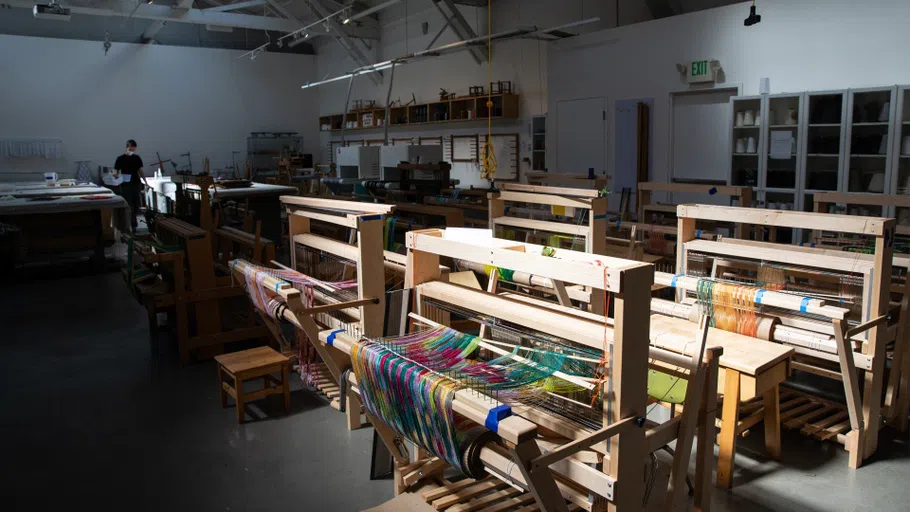 16 floor looms in a large studio. 