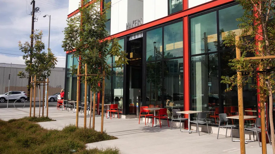 Exterior view of Makers Cafe, with tables lined up outside the building.