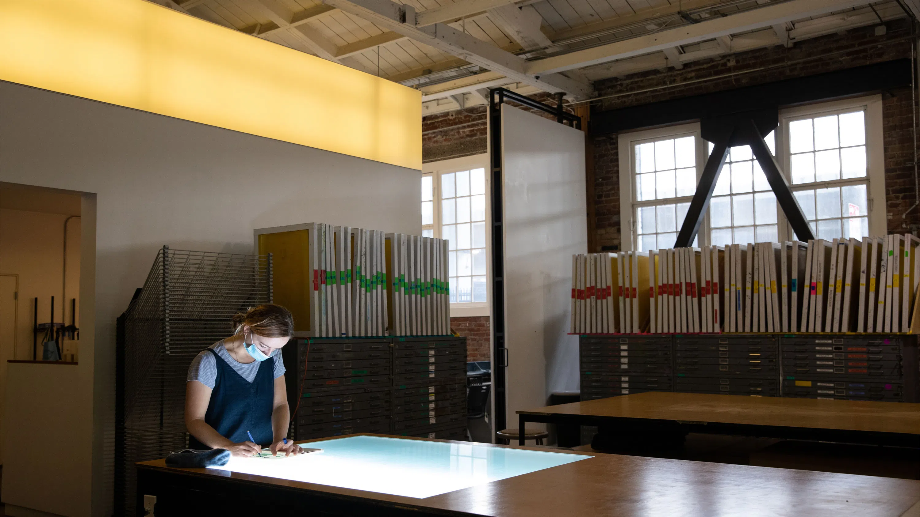 Student drawing on a lightbox.